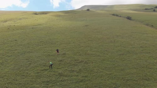 Aerial Shot of a Group of Tourists with Backpacks Climb the Mountain