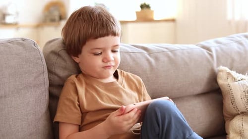 Child Using a Mobile Phone on Couch
