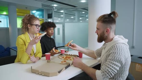 Young Adults Enjoying Pizza Together at Work