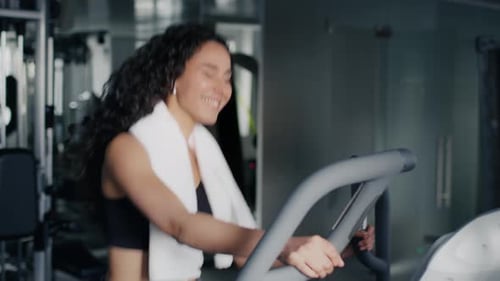 Active Woman Using Elliptical Machine in Gym