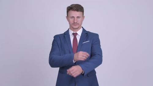 Man in Suit Crosses Arms and Smiles