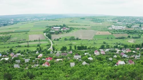 Flying Over a Dense Forest Then a Residential Rural Area