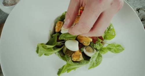 Close Up View of a Man Hand Chefprepares a Salad of Seafood and Vegetables Top View