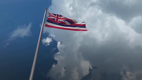 Hawaiian Flag Waving Against Cloudy Blue Sky