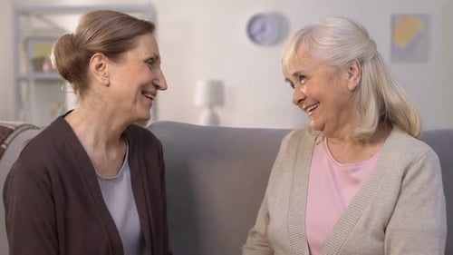 Senior Women Embracing on Sofa in Living Room