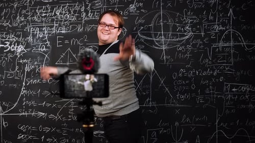 Man Dancing in Front of Chalkboard Recording Video