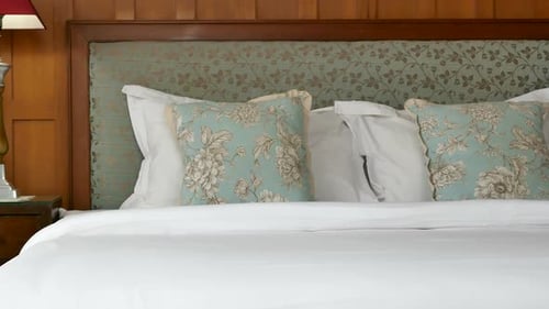 Luxurious Bed with Floral Pillows in Elegant Room