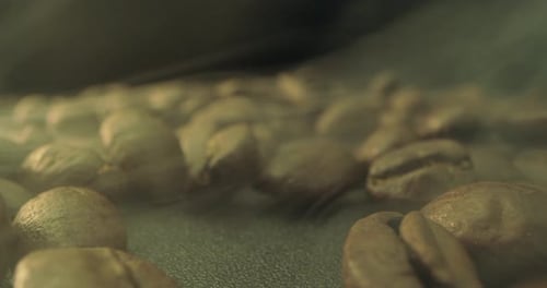 Closeup Shot of Roasting Coffee Beans Filmed in a Dark Key the Smoke Emanating From the Roasting of