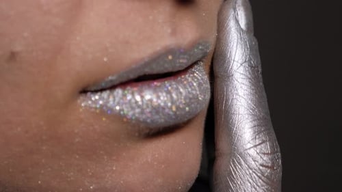 Woman's Glittering Silver Lips and Finger Close-up