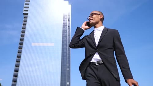 Diverse Businessman With Smartphone Talking Near Office Building