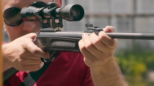 Close Up of the Face of a Man Aiming While Looking Into an Optical Rifle Sight.