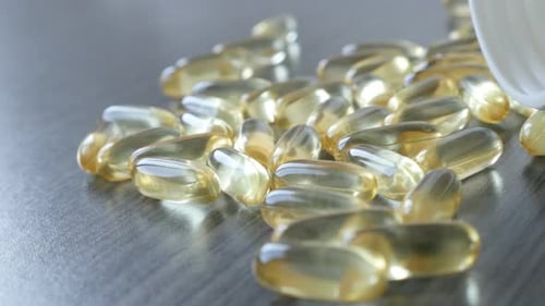 Slow pan on transparent omega-3 soft gel capsules 4K 2160p 30fps UltraHD footage - Fish oil supleme
