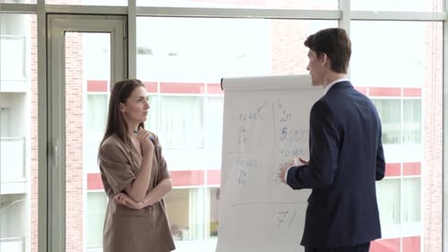 Business Professionals Discuss Strategy at Flip Chart