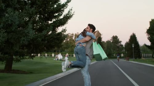 Couple in Love Having Fun in Summer Park After Successful Shopping
