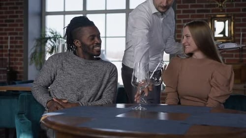 Happy Boyfriend and Girlfriend Talking in Restaurant As Waiter Setting Table in Slow Motion