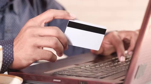 Männliche Hände halten Kreditkarte und verwenden Laptop online einkaufen