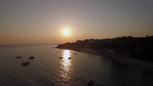 Sunset Scene of Resort and Sea with Boats, Aerial. Trikorfo Beach in Greece