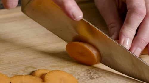 Slicing Carrots on a Wooden Cutting Board