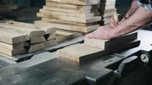 Man Smoothing Wood Planks on Industrial Jointer