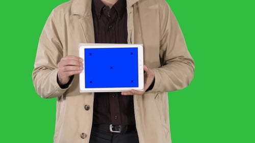 Person Holding Tablet with Blue Screen on Green