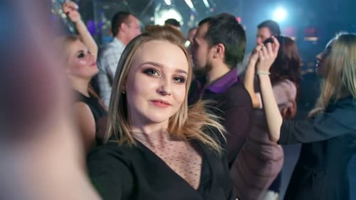 Pretty Woman is Taking a Selfie While Dancing at the Night Club