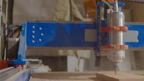 Woodworker Looking at Working CNC Machine