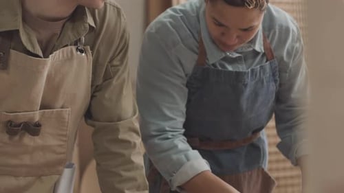 Two People Inspect Woodworking Component in Workshop