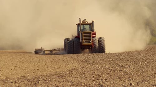 Tractor plowing field in slow motion