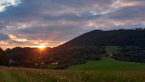 Sunset Over the Hills on a Green Meadow at Countryside in Summer FHD Timelapse