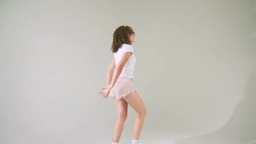 Young Woman With Curly Hair Dancing in Studio