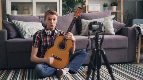 Man Records Himself Playing Guitar in Living Room