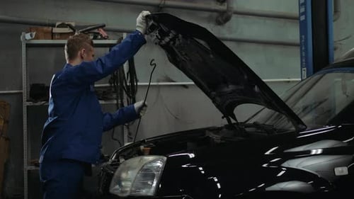 Mechanic Checking Oil Level in a Car Workshop Man Portrait Engine Car Repair Service
