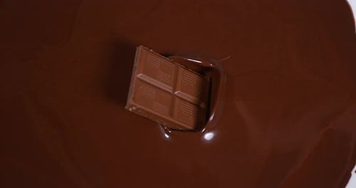 Chocolate Square Dropping Into Melted Chocolate Pool