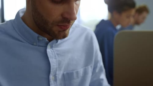 Man Writing in Notebook at Office Desk