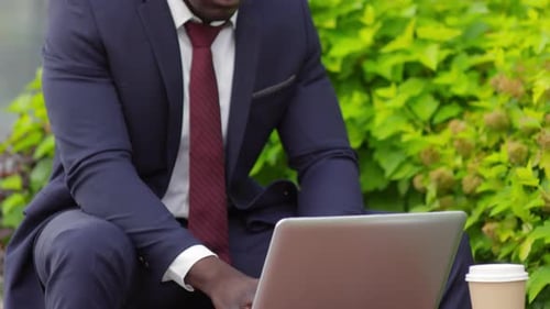 Businessman Uses Laptop in Urban Park