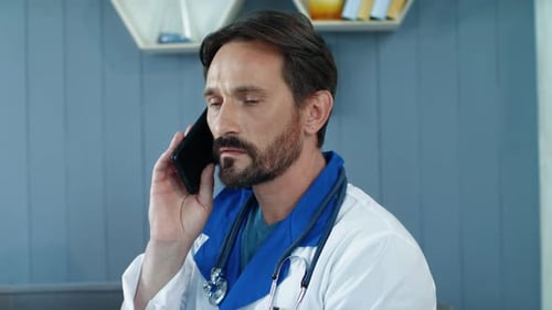Close Up Tired Male Doctor Talking Phone in Office. Doctor Listening Patient