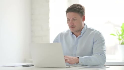 Man Celebrating Success at Office Desk