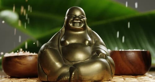 Primer plano de la figura de Buda riendo con una perla que cae