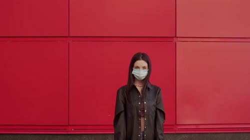 Woman with Facemask Holds Stop COVID Sign