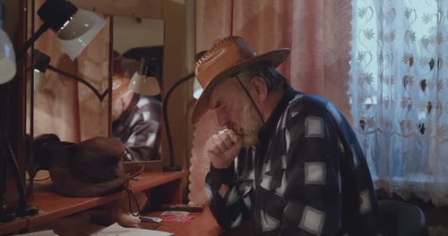 Senior Man Coughing and Blowing Nose Indoors