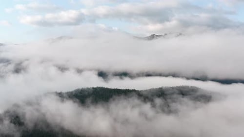 Aerial View of Mountains Through Clouds and Mist