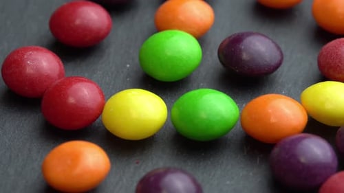 Farbige Fruchtbonbons drehen sich auf einem schwarzen Hintergrund Farbige Marco Sweets