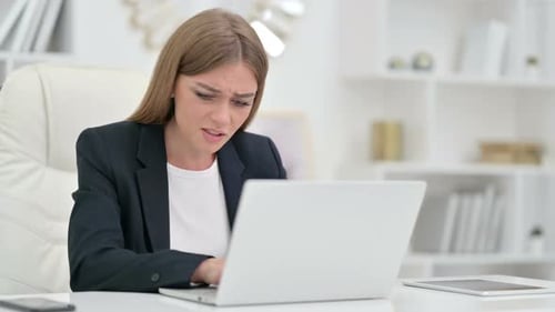 Worried Woman Working at Laptop in Office