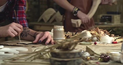 Young Hipster Painting Handmade Goods in her Studio