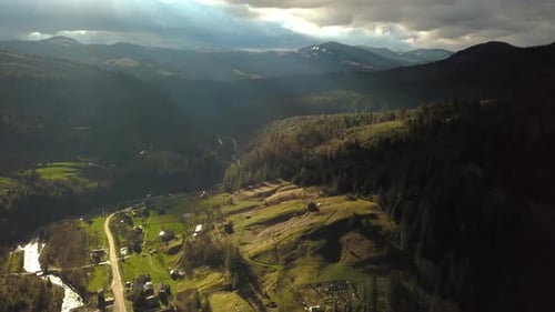 Luftaufnahme von Gewitterwolken und einem Dorf in den Bergen