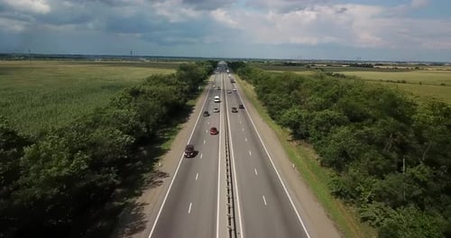 Aerial View of Highway Road with Cars and Truck Between Green Meadow