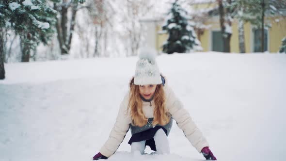 Child is Scattering Snow By Her Hands on the Background of Snowfall in ...