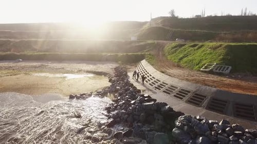 Group of People Having Fun Near Sea Wall in Slowmotion During Sunrise