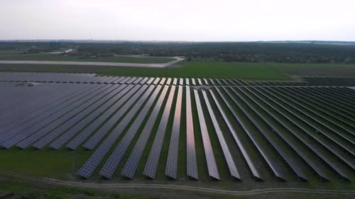 Aerial Drone View Into Large Solar Panels at a Solar Farm at Cloudy Summer Evening. Solar Cell Power