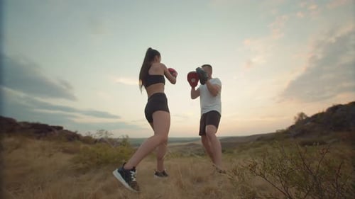 Woman and Man Practicing Boxing in Rural Setting